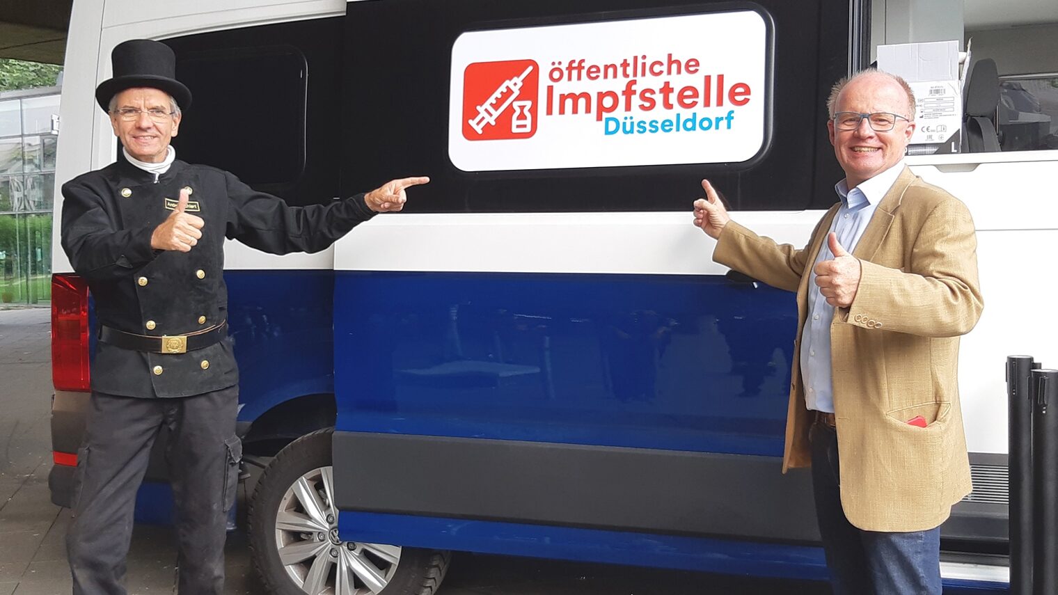 Kammerpräsident Andreas Ehlert und stv. Kreishandwerksmeister Jörg Schmitz stehen vor dem Impfbus mit Daumen hoch.