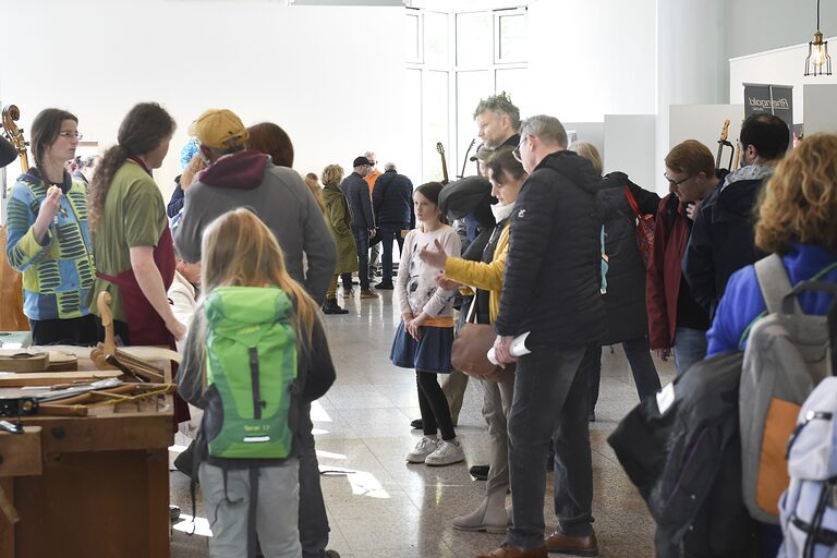 Besucher gehen durch die Ausstellung der Musikinstrumentenmacher im Foyer der Handwerkskammer