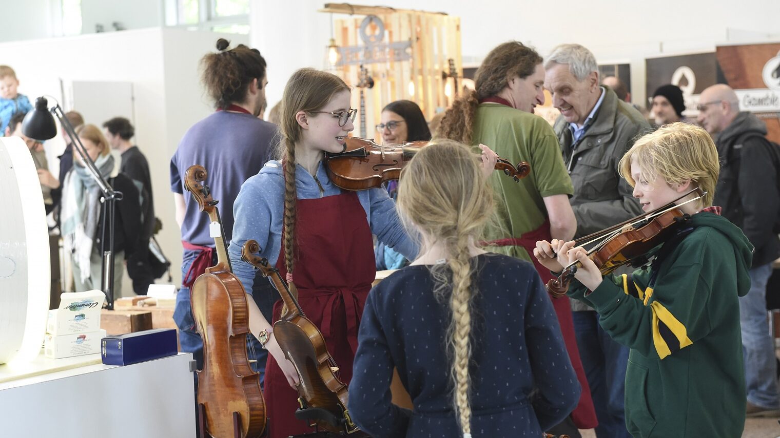 Kinder am Stand eines Geigenbauers
