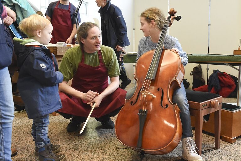 Geigenbauer Rodolfo Angilletta und ein Kind mit Cello