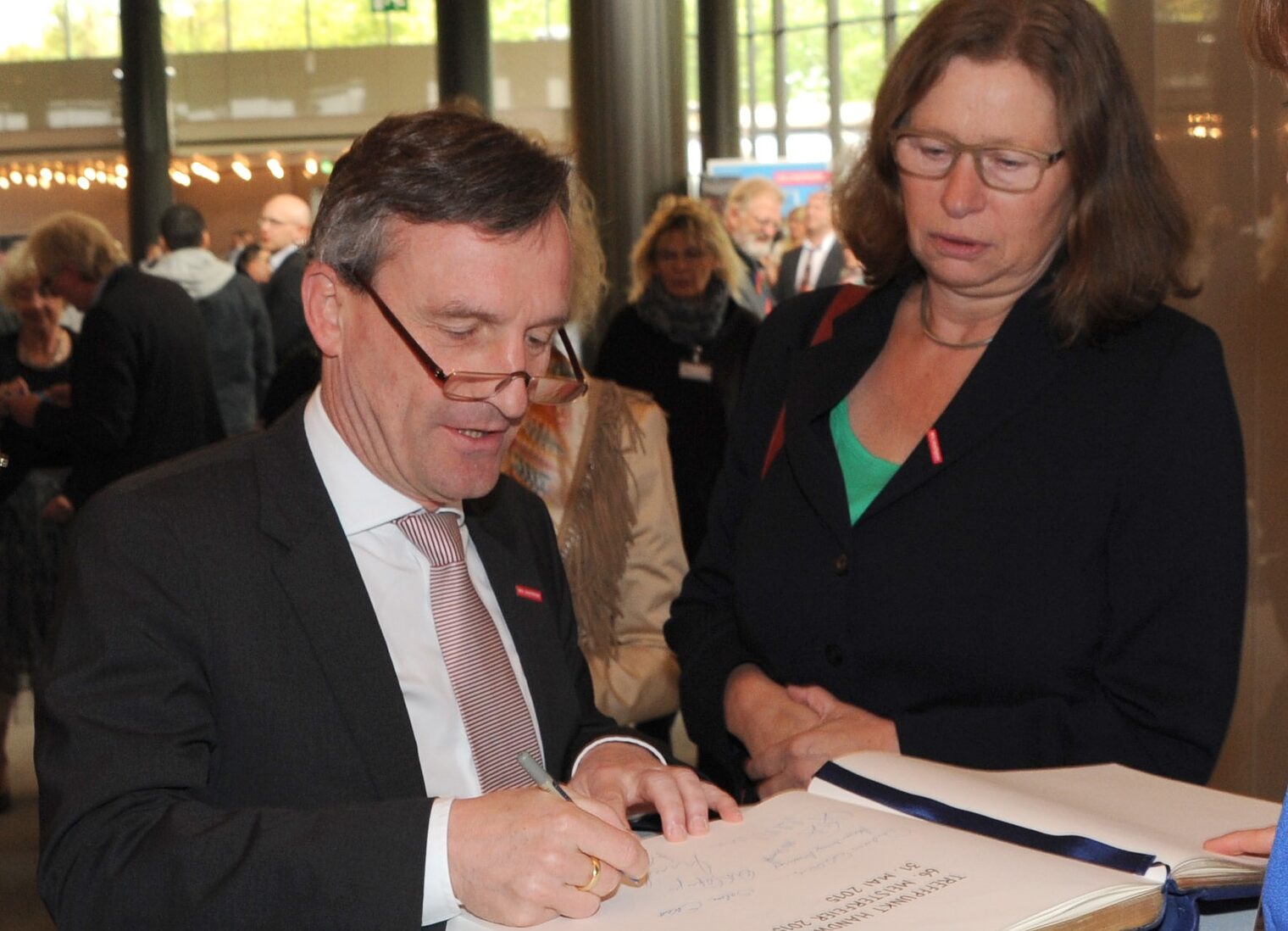 OB Thomas Geisel und Anne Lütkes, Regierungspräsidentin im Reg.-Bezirk Düsseldorf, tragen sich in das Gästebuch ein.