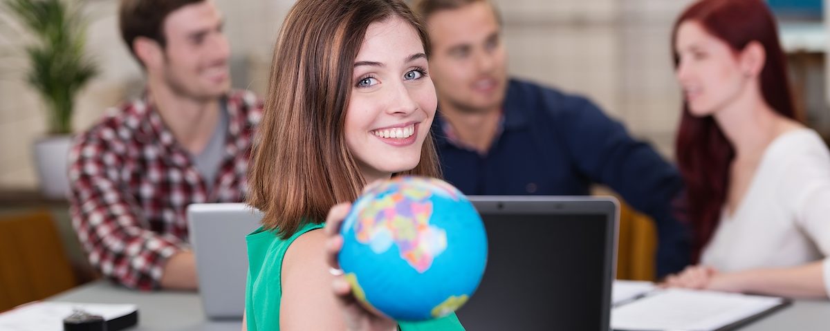 Lernen und arbeiten im Ausland während der Ausbildung. Junge Frau mit Globus in der Hand.