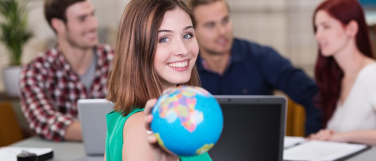 Lernen und arbeiten im Ausland während der Ausbildung. Junge Frau mit Globus in der Hand.