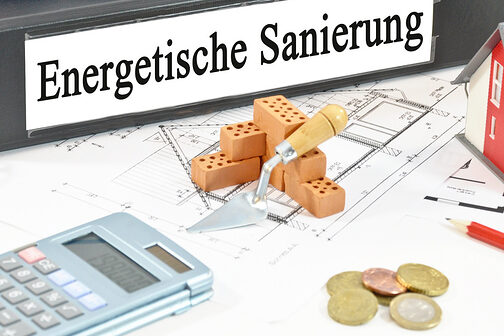 Illustration mit Aktenordner, Mini-Haus, Münzen, Bleistift, Brille und Taschenrechner