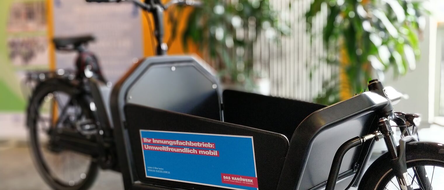 Ein Lastenrad steht als Schaustück in einem Raum