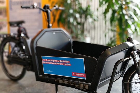 Ein Lastenrad steht als Schaustück in einem Raum
