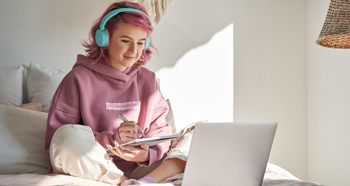 Mädchen mit Kopfhörer arbeitet mit Laptop