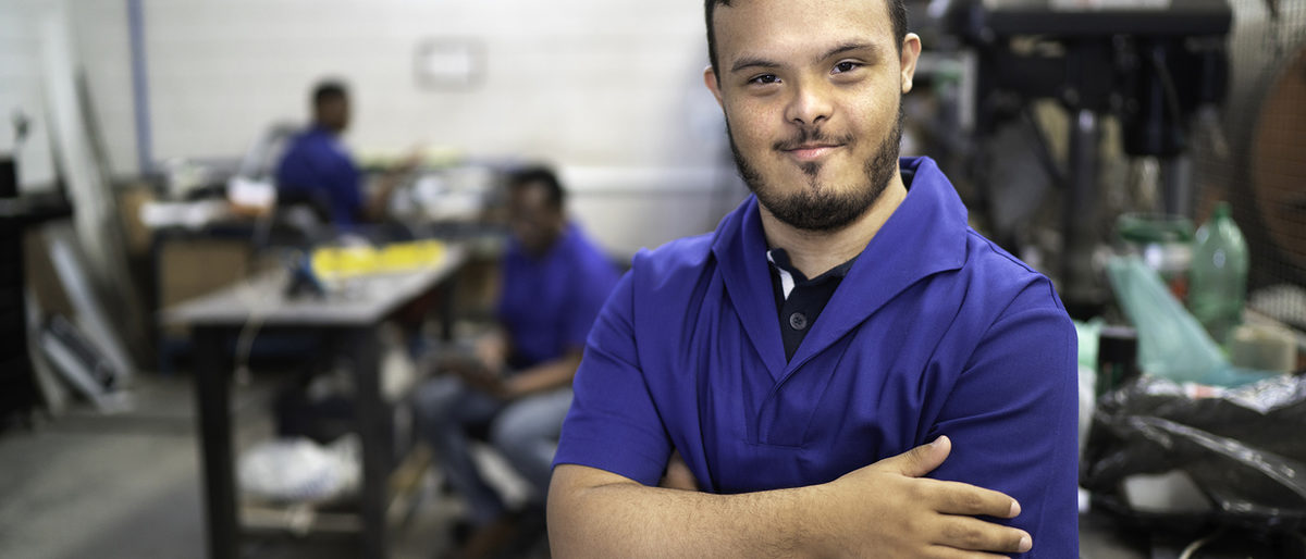 Portrait of smiling special needs employee in industry