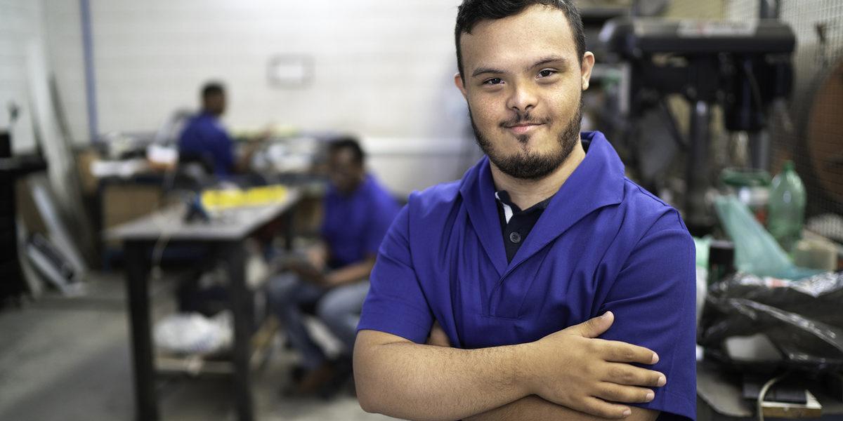Portrait of smiling special needs employee in industry