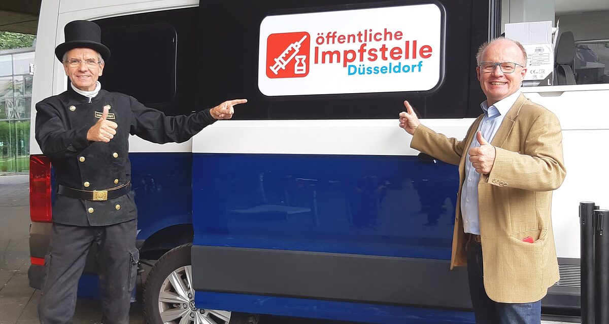 Kammerpräsident Andreas Ehlert und stv. Kreishandwerksmeister Jörg Schmitz stehen vor dem Impfbus mit Daumen hoch.