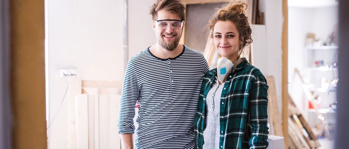 Junges Paar in seinem Tischler-Betrieb