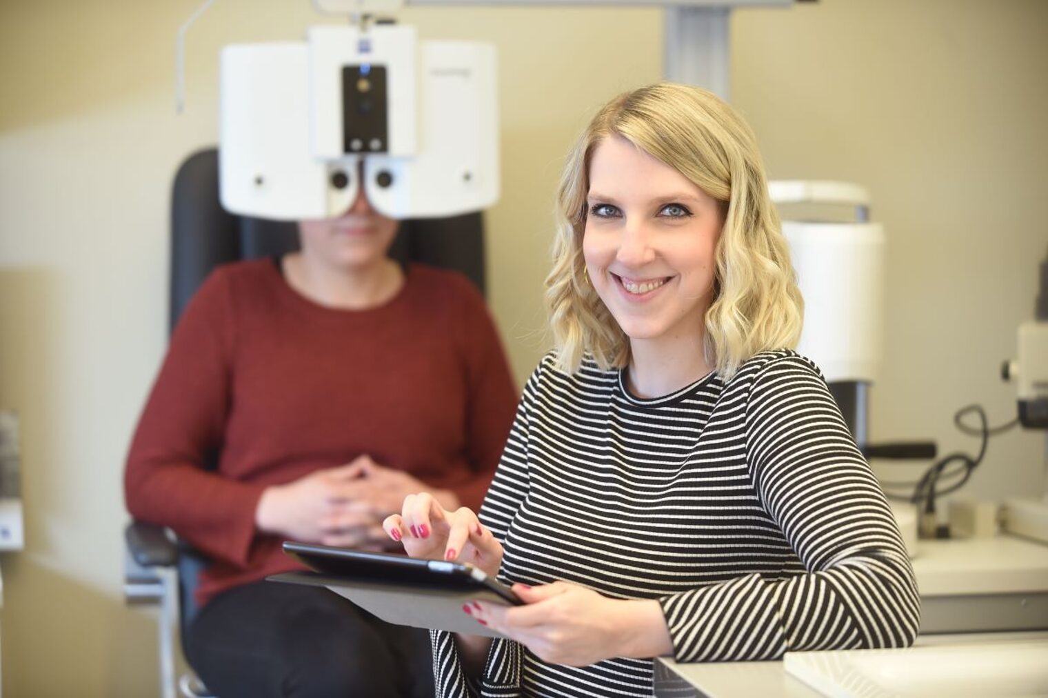 Augenoptikerin Jennifer Gerecke beim Vermessen der Augen einer Kundin
