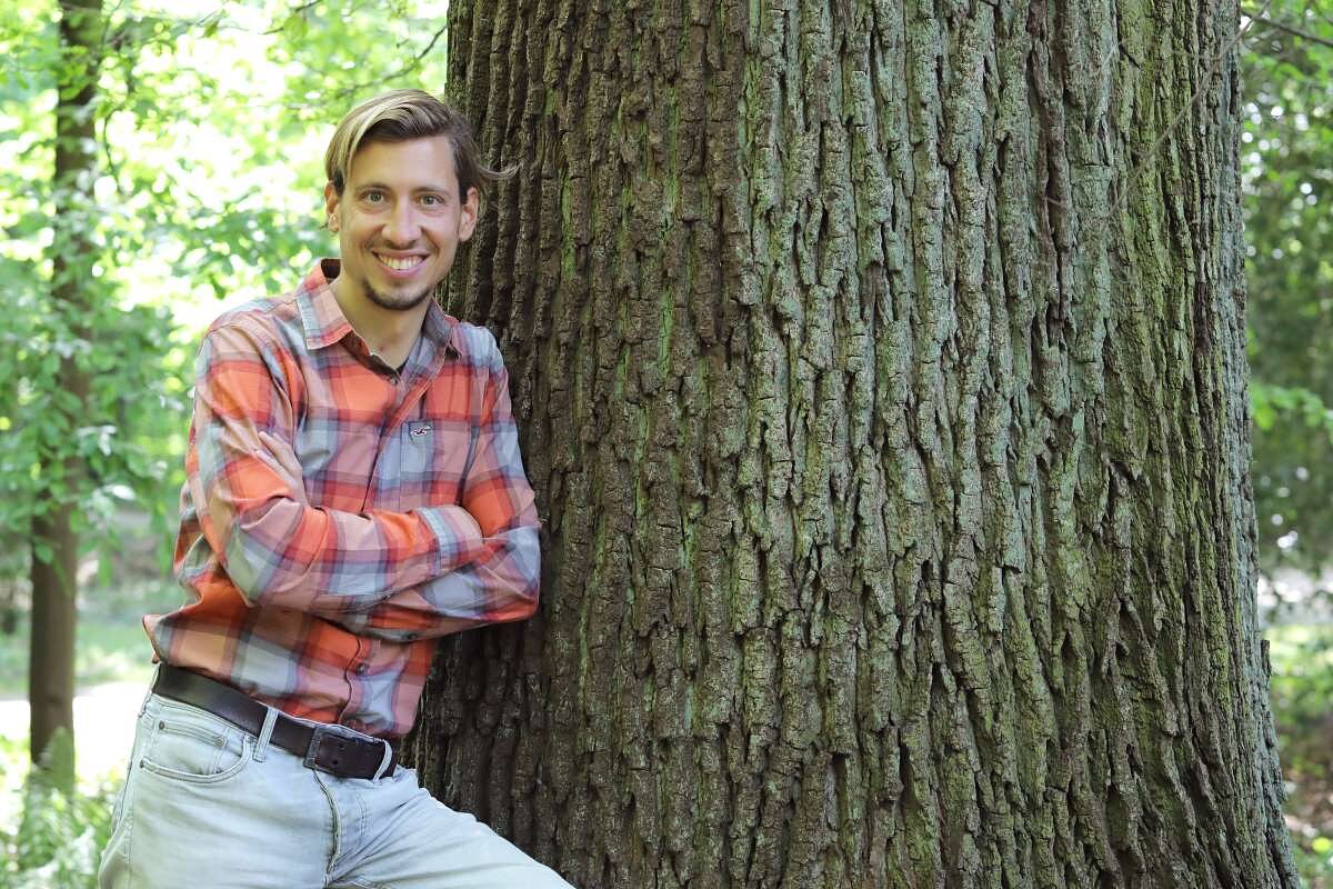 Tischler Vogler lehnt sich an einen Baum.