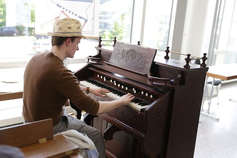 Mann spielt an einem altmodischen Piano