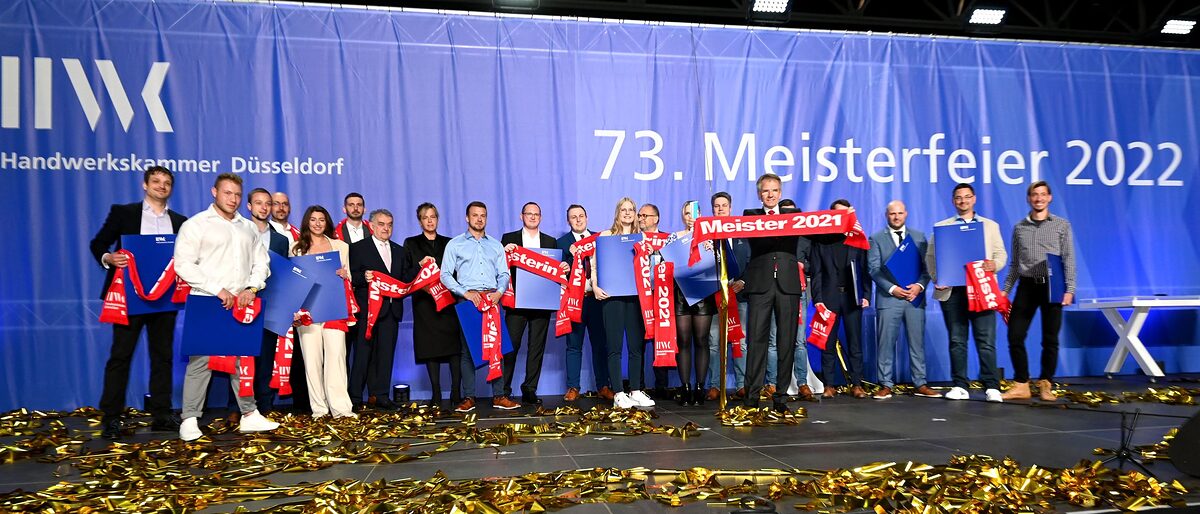 Die 17 Jahresbesten auf der Meisterfeier-Bühne mit Landesinnenminister Herbert Reul (7.v.l.), der Grünen-Vorsitzenden Mona Neubaur (8.v.l.) und HWK-Präsident Andreas Ehlert (5.v.r.). Die Jahresbesten auf der Bühne