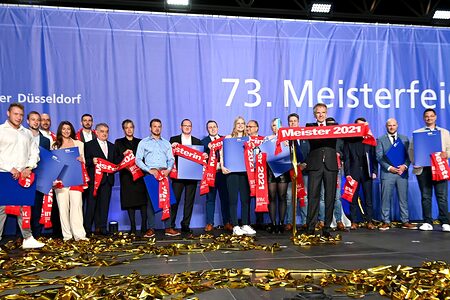 Die 17 Jahresbesten auf der Meisterfeier-Bühne mit Landesinnenminister Herbert Reul (7.v.l.), der Grünen-Vorsitzenden Mona Neubaur (8.v.l.) und HWK-Präsident Andreas Ehlert (5.v.r.). Die Jahresbesten auf der Bühne