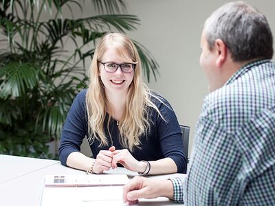 Eine junge Frau im Gespräch mit einem Ausbildungsberater oder Personaler.