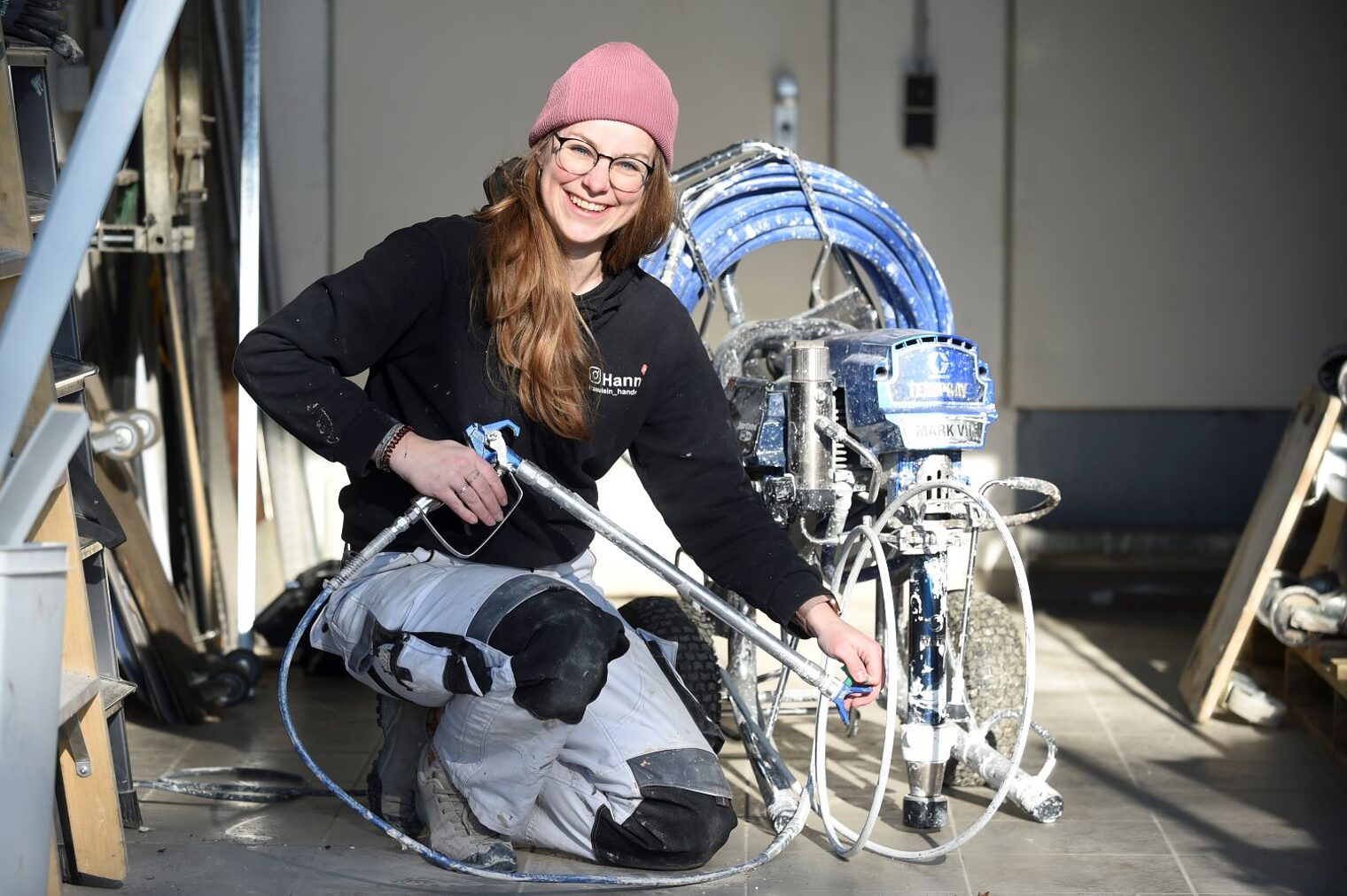 Hanna Kießler kniet neben einer Spritzmaschine