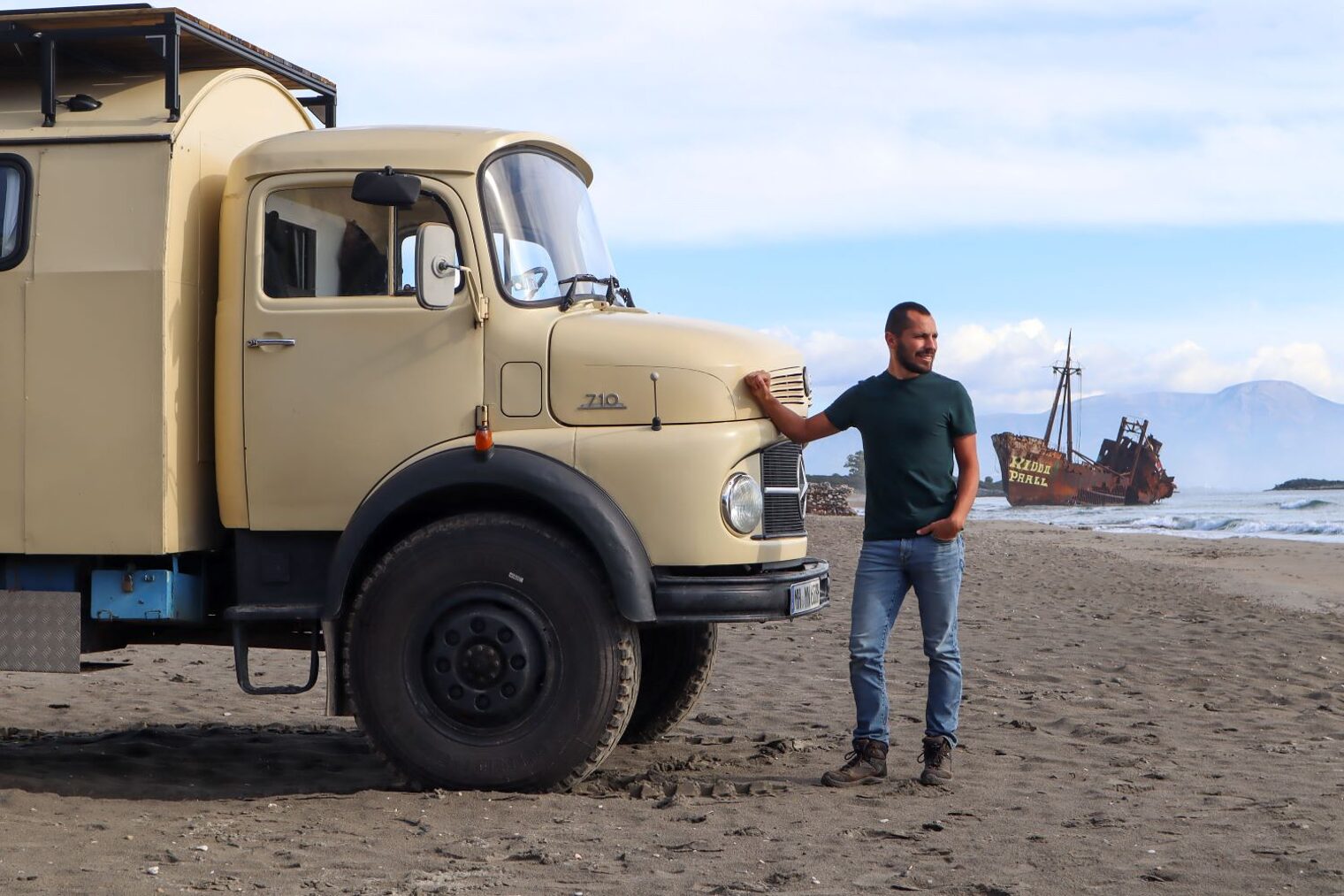 Niklas Remberg an einem Strand vor seinem Oldtimer-LKW