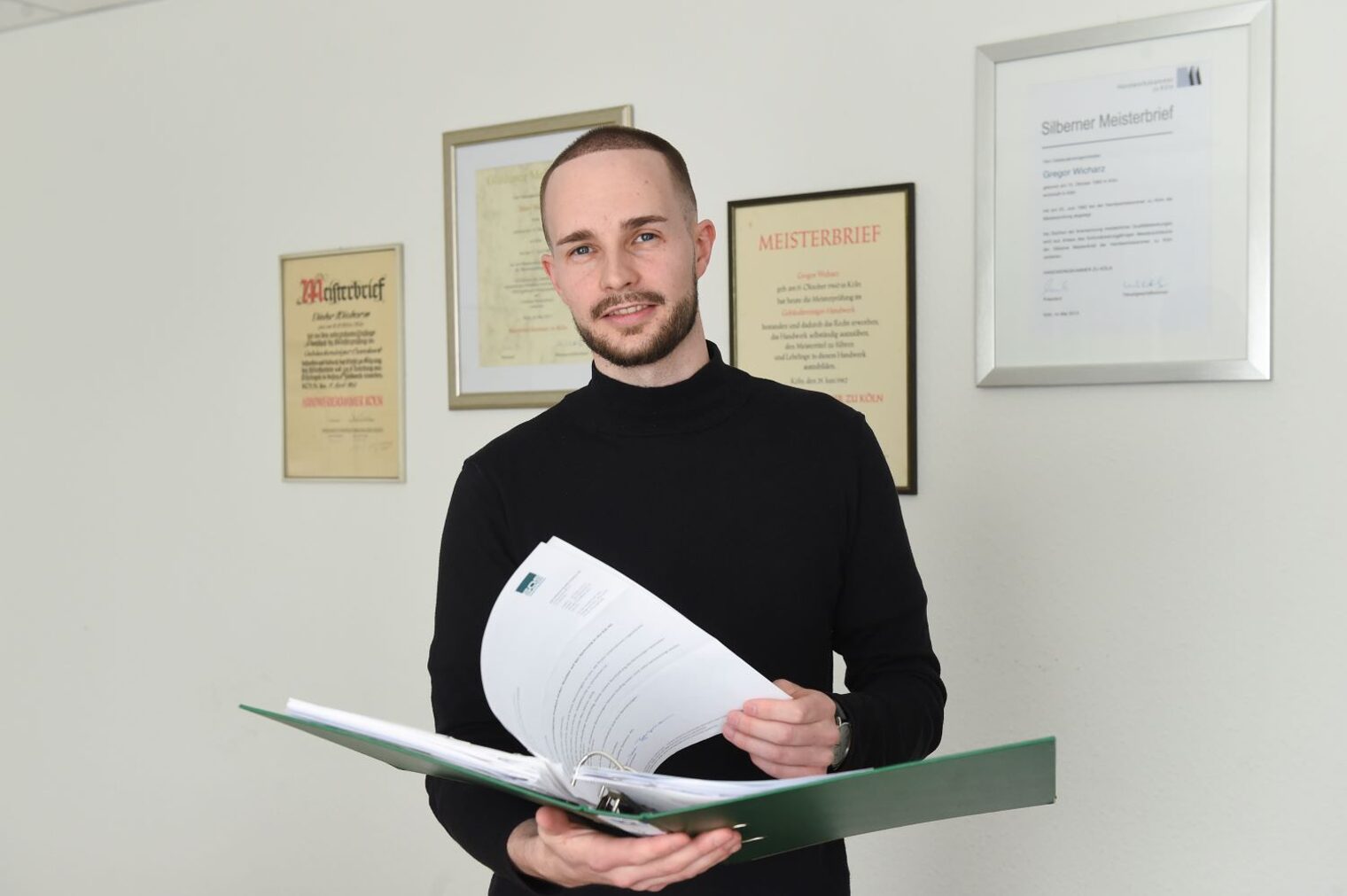 Rene Wicharz blättert in einem Arbeitsordner
