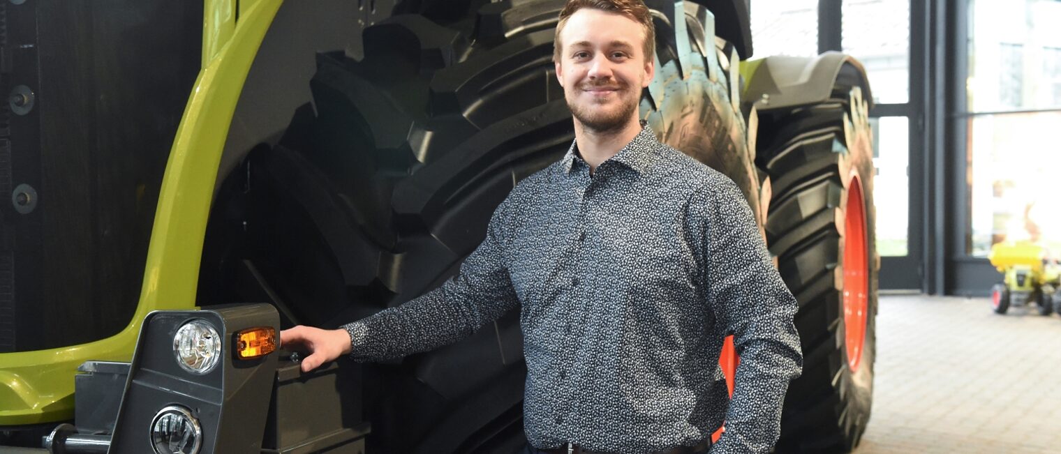 Henrik Eikmeier steht vor einer Landmaschine