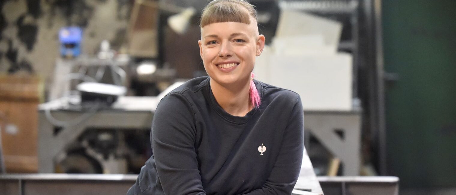 Sandrina Wulf lehnt an einer Werkbank