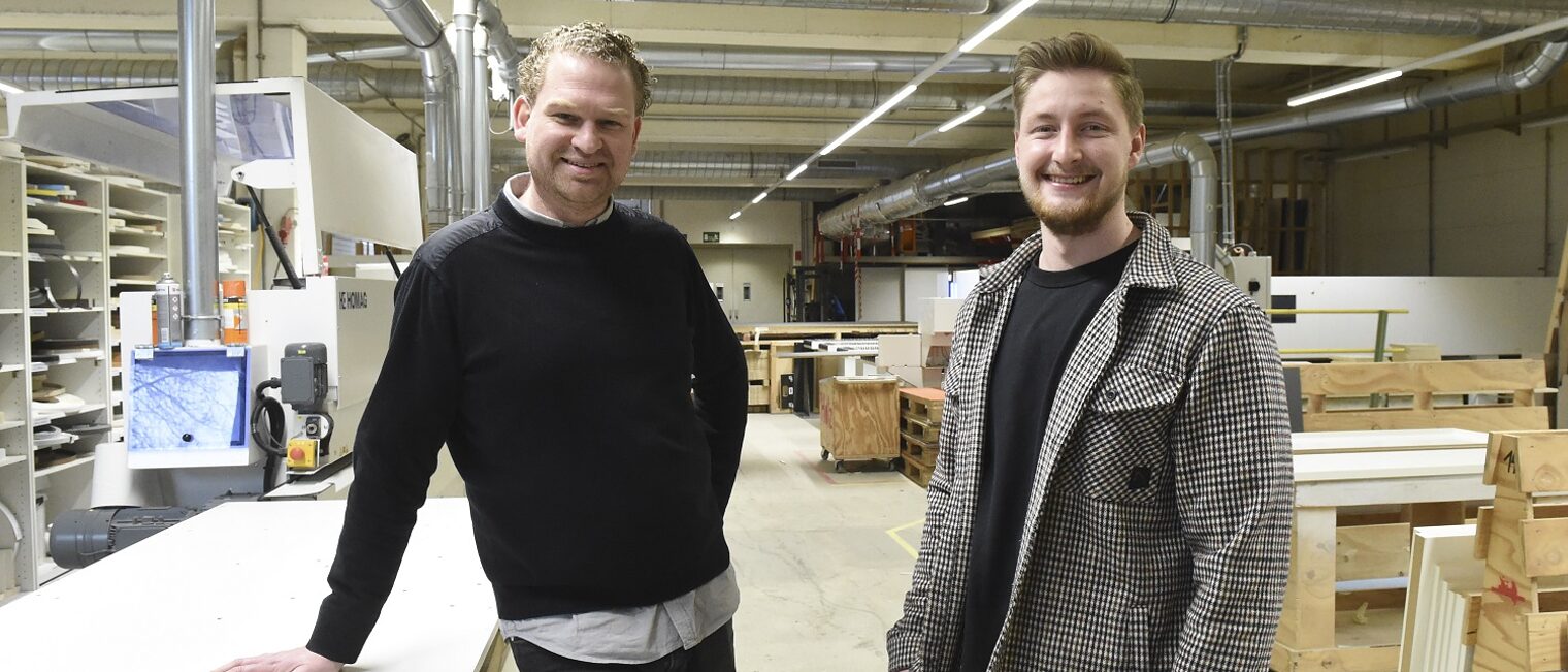 Daniel Heller (l.) und Nils Rebel in den großzügigen Werkstatträumen der Tischlerei im Düsseldorfer Süden Geschäftsführer und Mitarbeiter einer großen Tischlerei stehen zusammen in der Werkstatt.