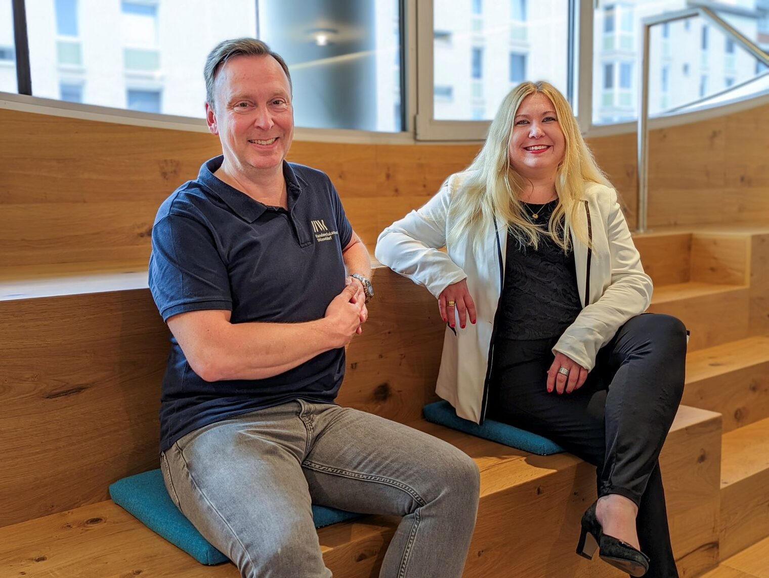 Thomas Pohl und Nadine Rosenau aus der Ausbildungsberatung sitzen zusammen auf einer Treppe.