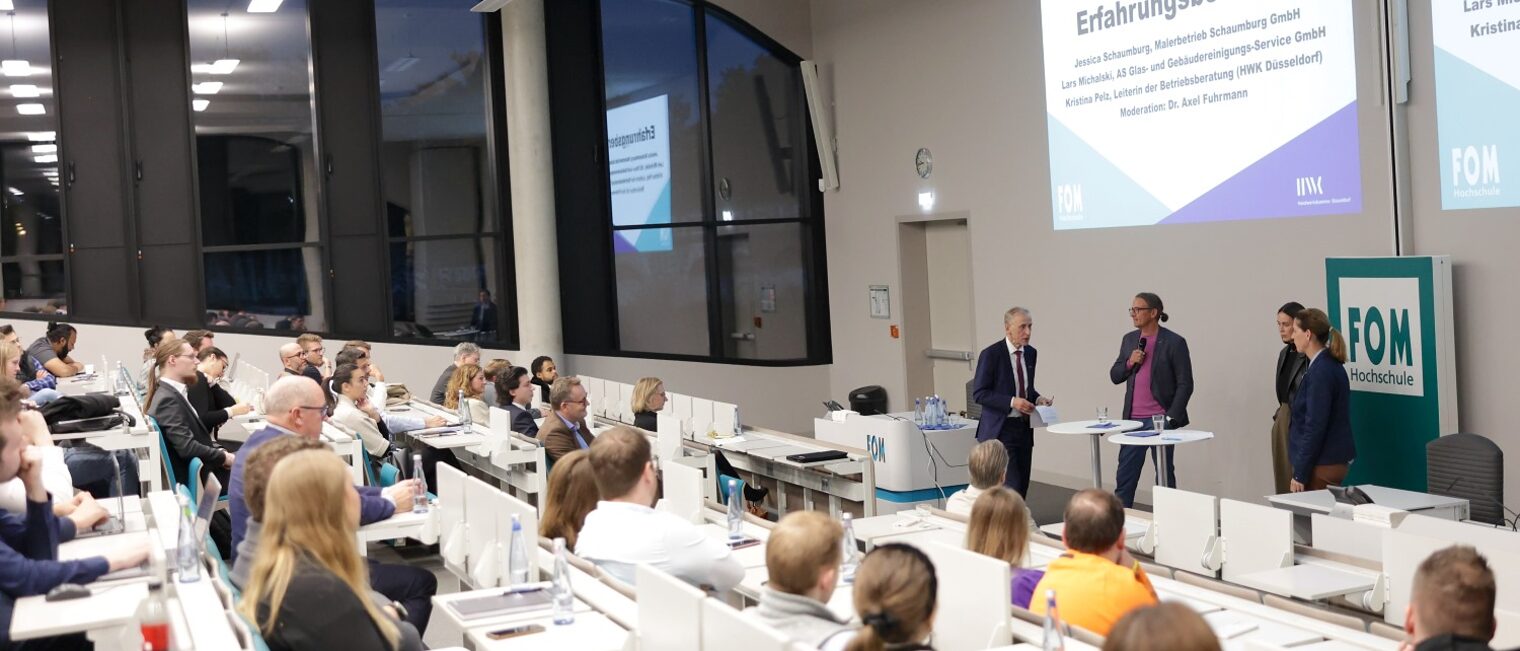 Hörsaal der Hochschule FOM mit Gästen und Rednern.