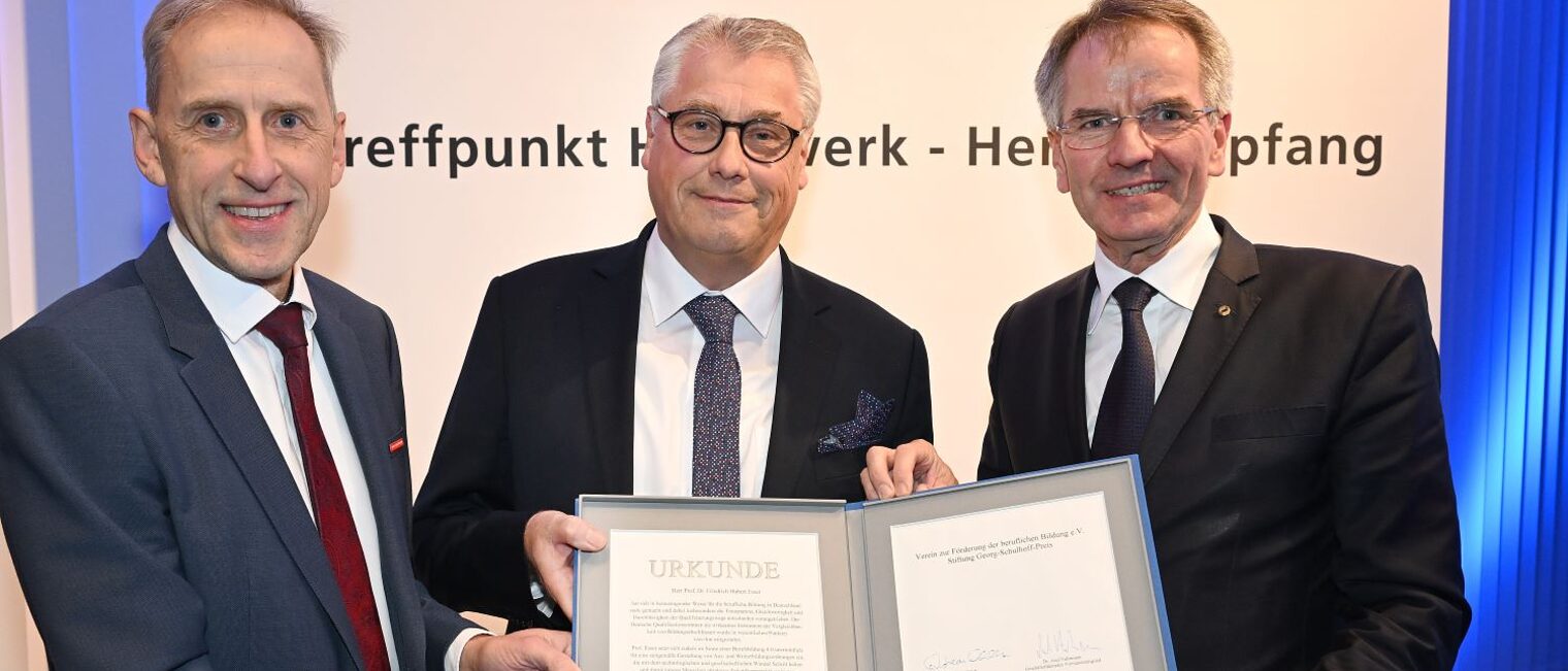Der Preisträger Prof. Esser zeigt seine Urkunde. Mit dabei auf dem Foto sind Kammerpräsident Andreas Ehlert und Kammer-Hauptgeschäftsführer Axel Fuhrmann.
