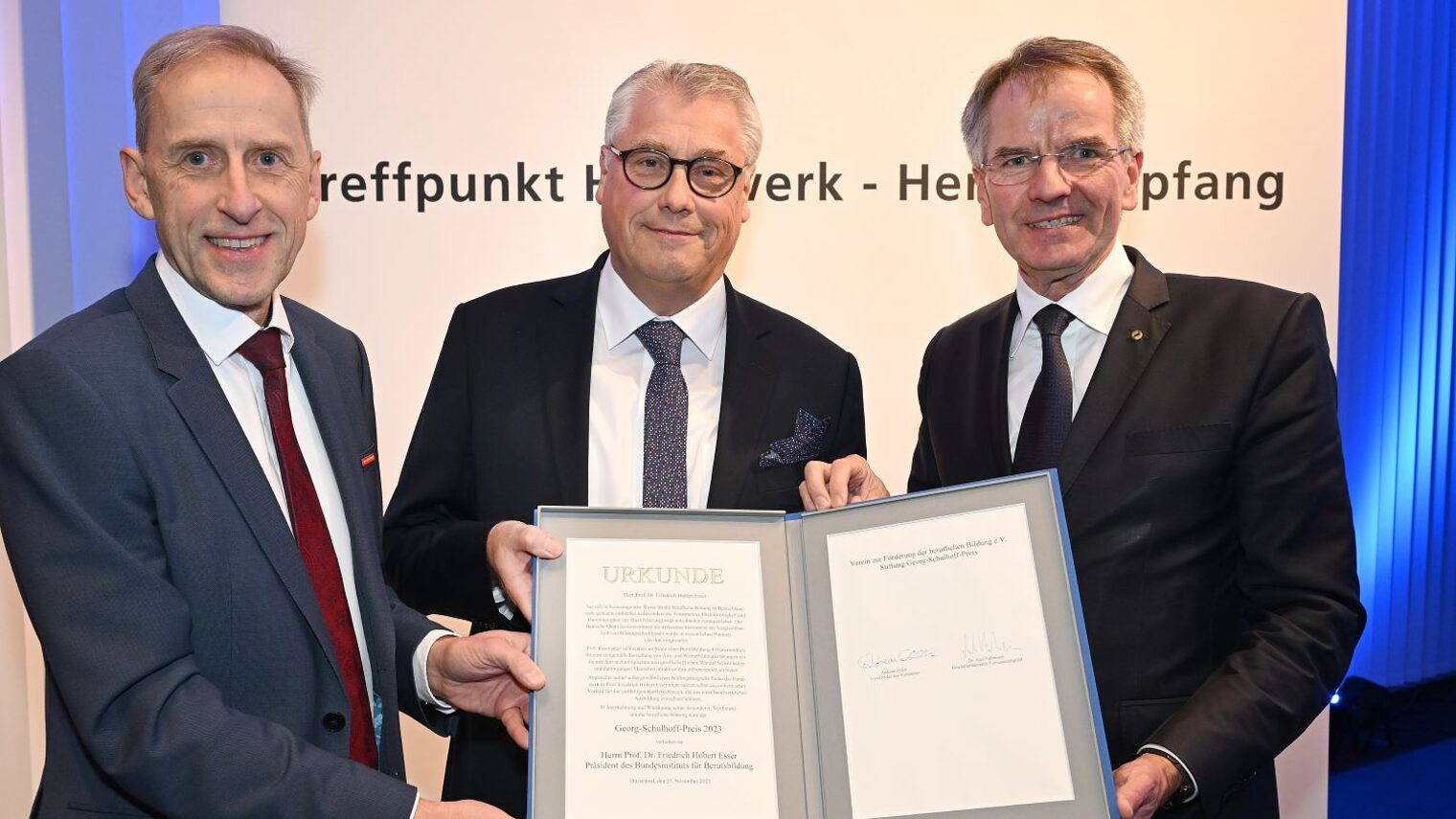 Der Preisträger Prof. Esser zeigt seine Urkunde. Mit dabei auf dem Foto sind Kammerpräsident Andreas Ehlert und Kammer-Hauptgeschäftsführer Axel Fuhrmann.