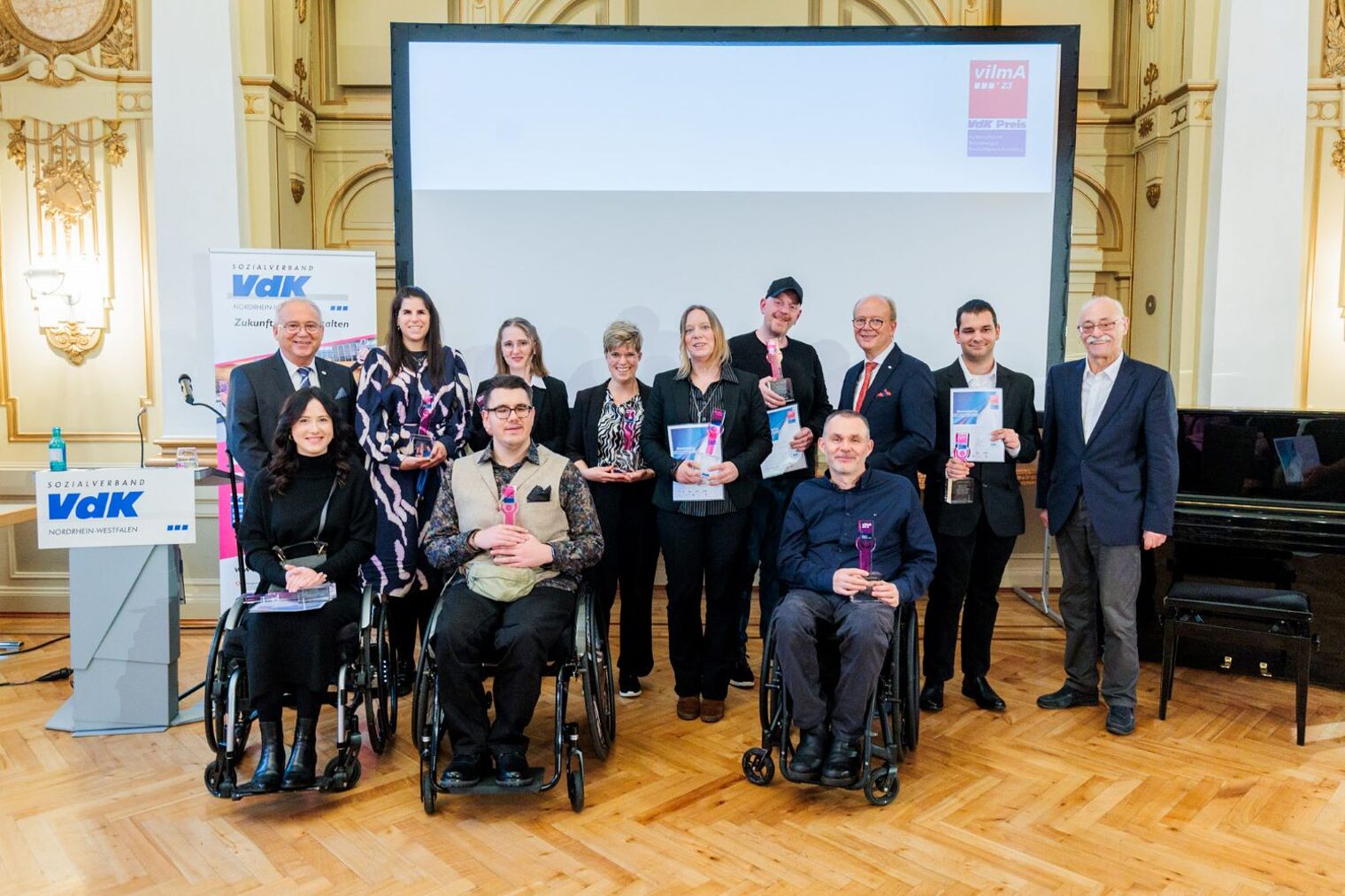 Gruppenbild mit den Gewinnerinnen und Gewinnern des VilmA-Preises 2023: NRW-Landtagspräsident und Schirmherr André Kuper, VdK-Landesvorsitzender Horst Vöge und vilmA-Juryvorsitzender Wilfried Böhm.