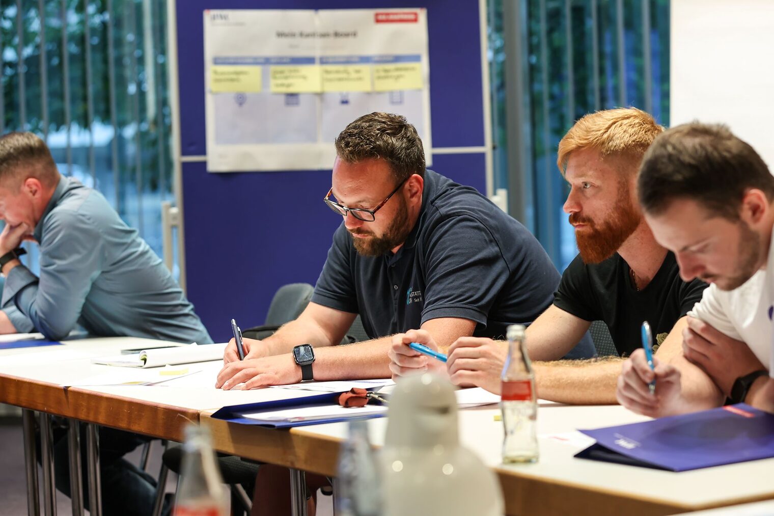 Teilnehmende in einem Workshop machen sich Notizen.