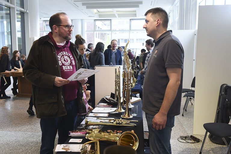 Mann im Gespräch mit Blasinstrumentenmacher Patrick Knorr