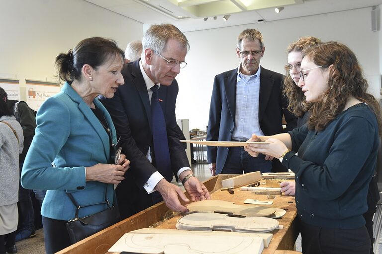 Kammerpräsident Andreas Ehlert lässt sich die Technik im Geigenbau erklären