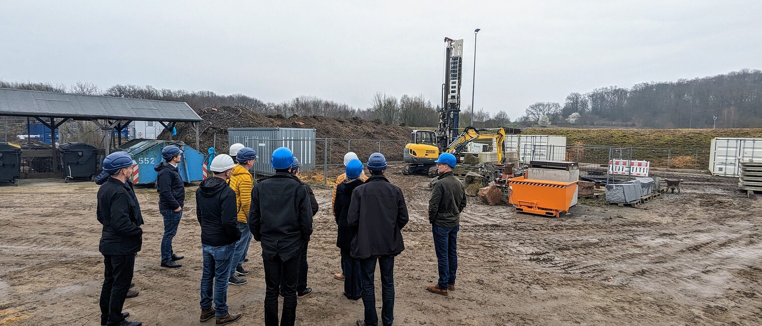 Internationales Geothermiezentrum (GZB) in Bochum Besuchergruppe mit Geothermiebohrung im Hintergrund