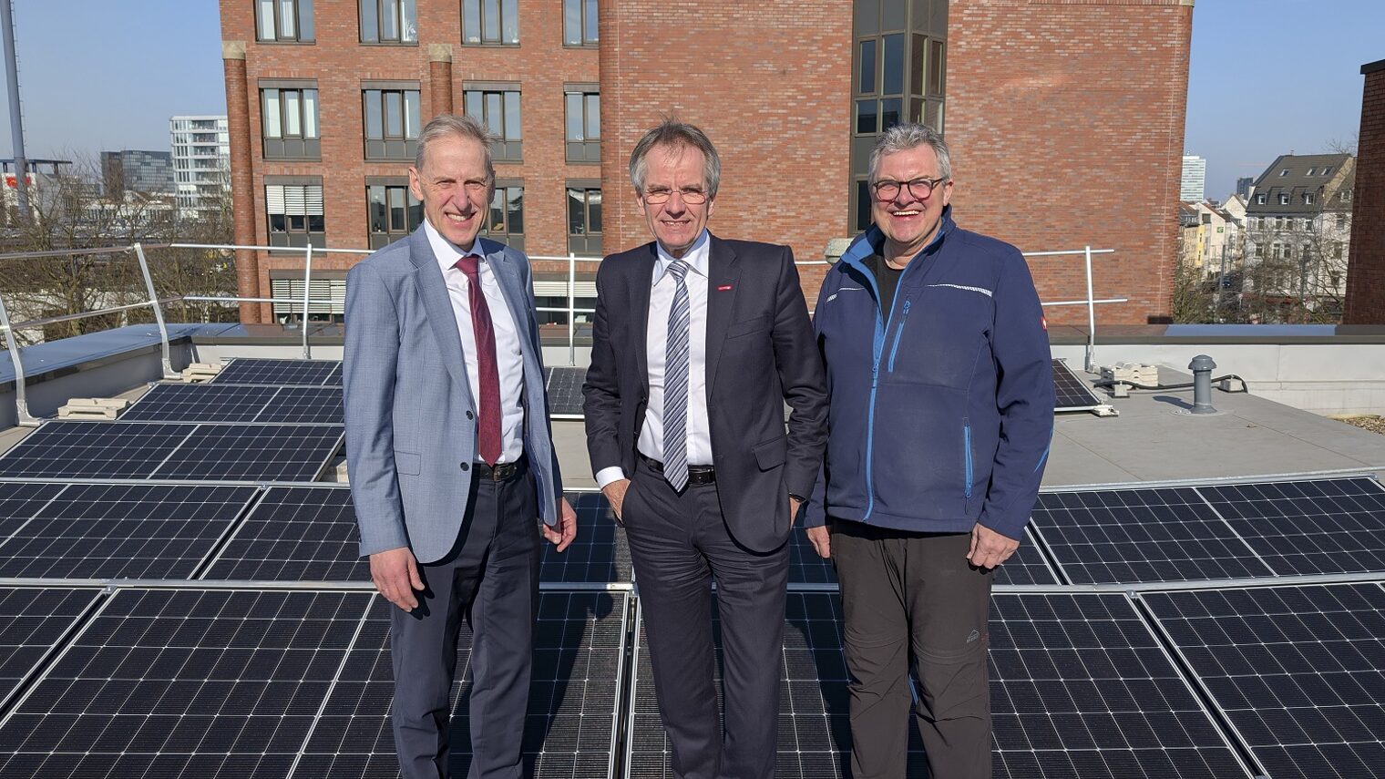 (v.l.) Hauptgeschäftsführer Dr. Axel Fuhrmann, Kammerpräsident Andreas Ehlert und Dieter Bellen, Leiter Haustechnik stehen zwischen den Modulen der neuen PV-Anlage auf dem Dach des Kammergebäudes D