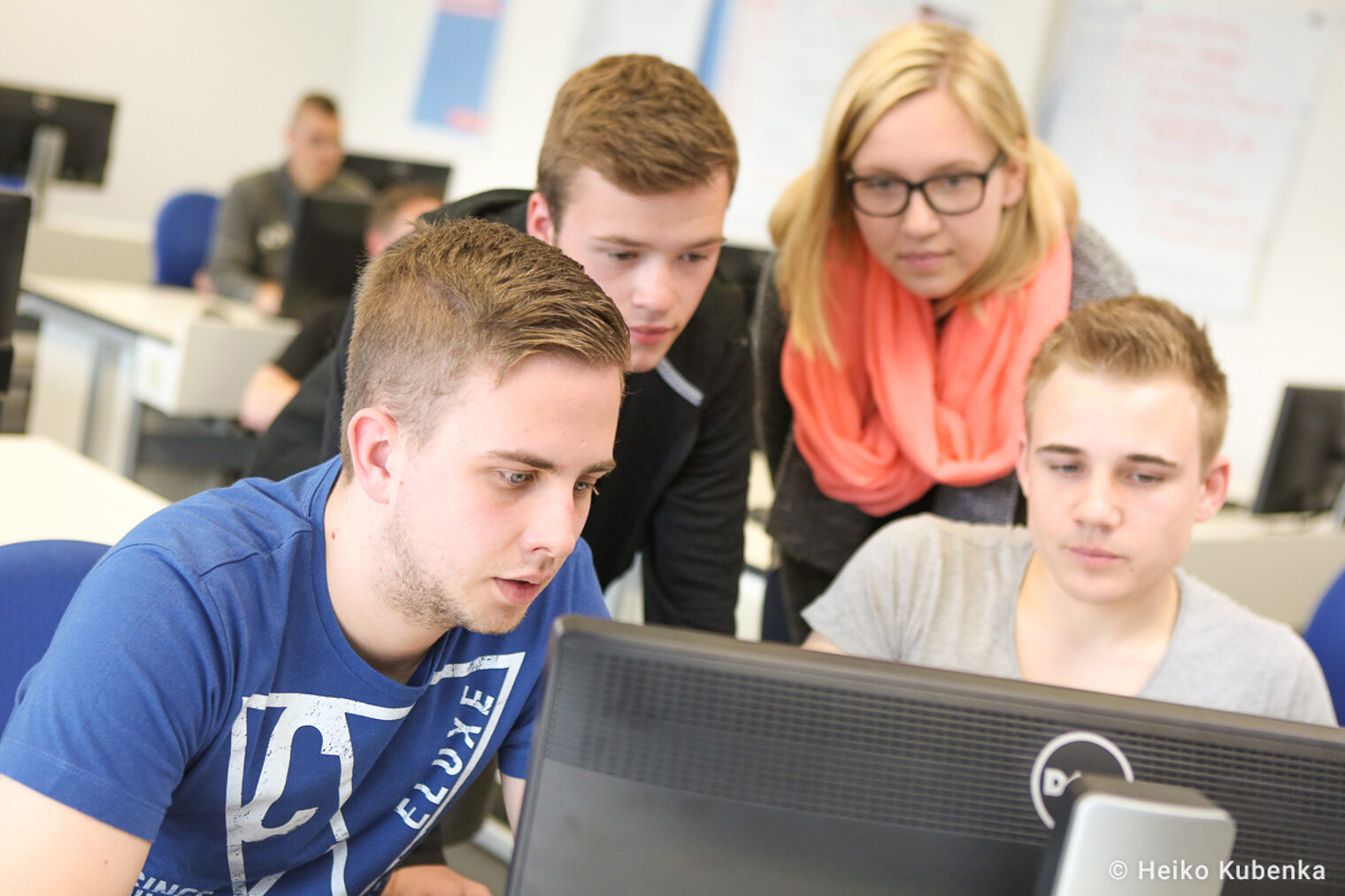 Gruppe von jungen Erwachsenen arbeitet gemeinsam an einem Computer