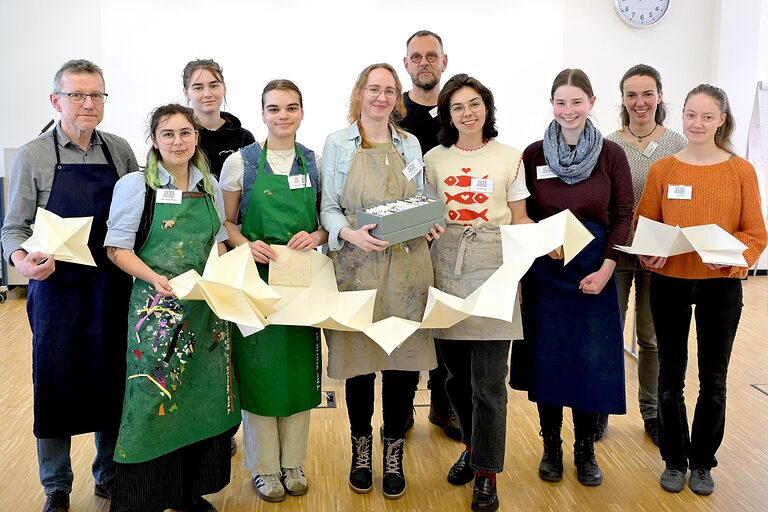 Gruppenbild mit 8 Teilnehmenden eines Azubi-Workshops für Buchbinder mit ihren beiden Dozenten