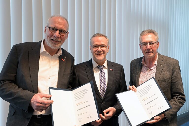 Maik Beckmann (l.) und Ludwig Voss (r.), Vorsitzender und Geschäftsführer des BDBI (mit Urkunden) nach ihrer Ehrung.