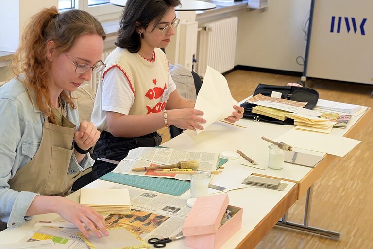 2 Auszubildende bei der Arbeit im Buchbinder-Workshop
