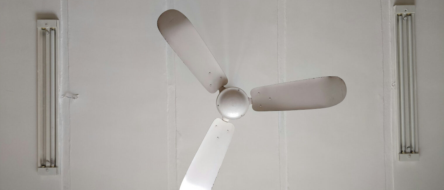 Zu sehen ist ein Deckenventilator, der von unten fotografiert wurde.