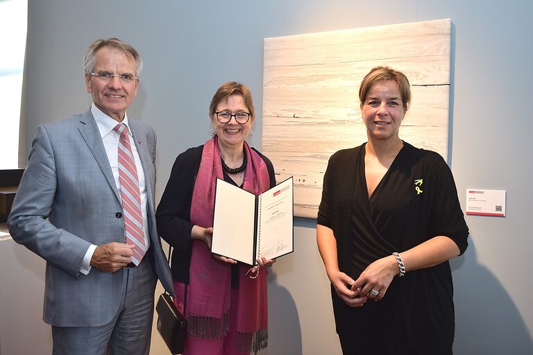 Preisträgerin Gabi Mett mit Andreas Ehlert und Mona Neubaur vor ihrem preisgekrönten Wandobjekt