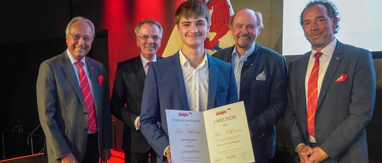 Gruppenfoto mit Preisträger Luc Schroers, der seine Urkunde in den Händen hält.