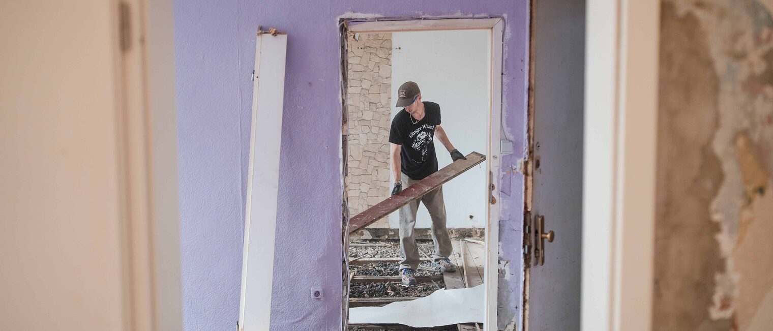 Ein Teilnehmer der Sommer School 2025 von Baukultur. NRW demontiert Dielenbretter. 