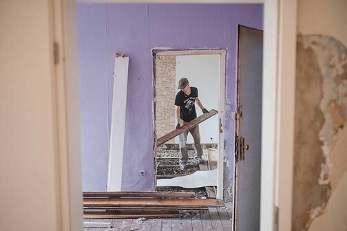 Ein Teilnehmer der Sommer School 2025 von Baukultur. NRW demontiert Dielenbretter.