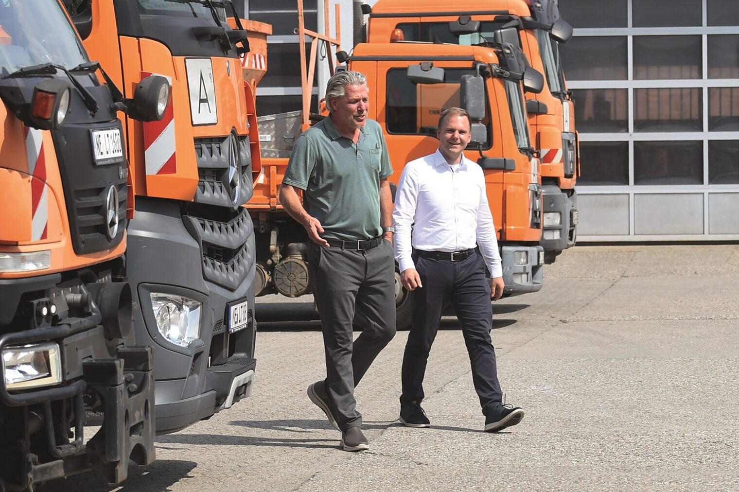 Torsten Krah und Ron Ritzer, Geschäftsführer der L.T.G. Neuss, laufen über den Parkplatz des Firmengeländes.