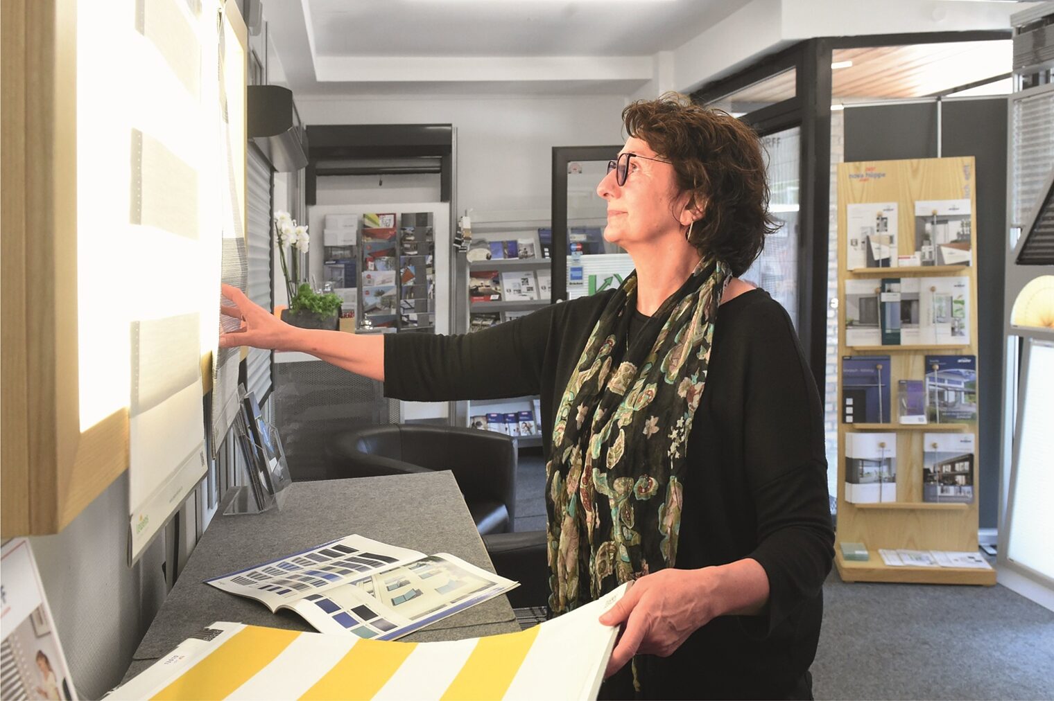 Sonnenschutztechnikern Vassiliki Werres-Vogels betrachtet Markisenstoffe in ihrem Geschäft.