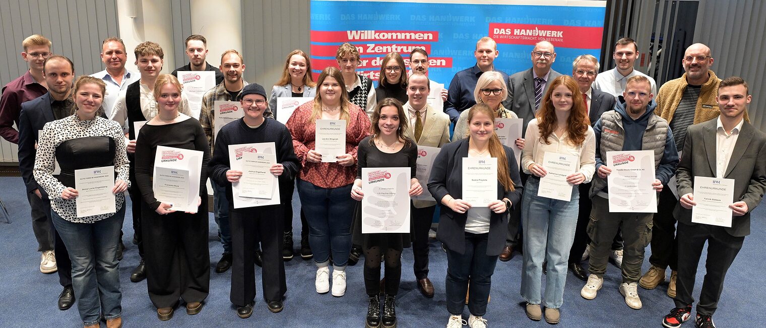 Die Teilnehmenden posieren für ein Pressefoto. Sie zeigen stolz ihre Urkunden.