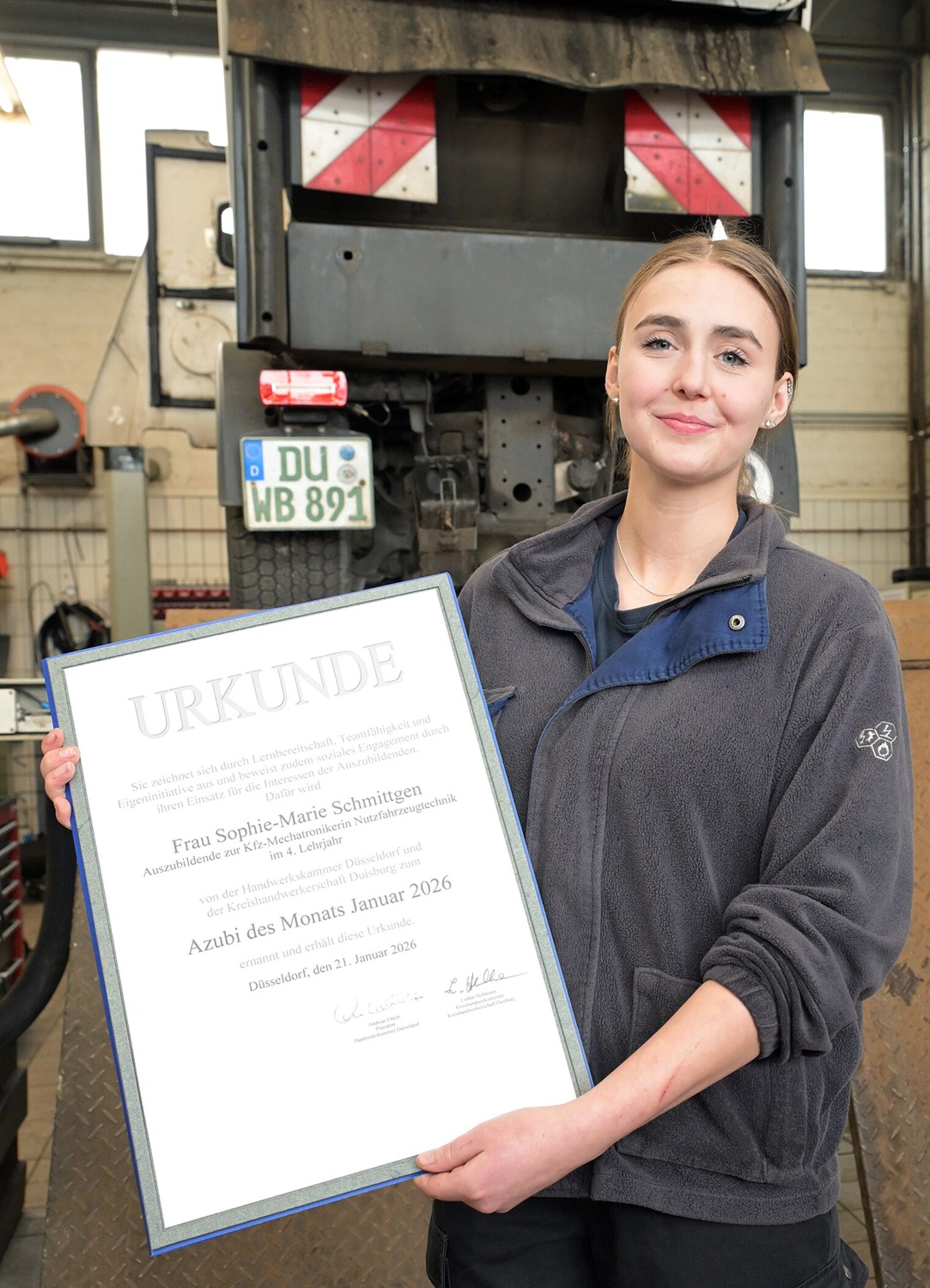 Sophie-Marie Schmittgen, Azubi des Monats, zeigt ihre Urkunde